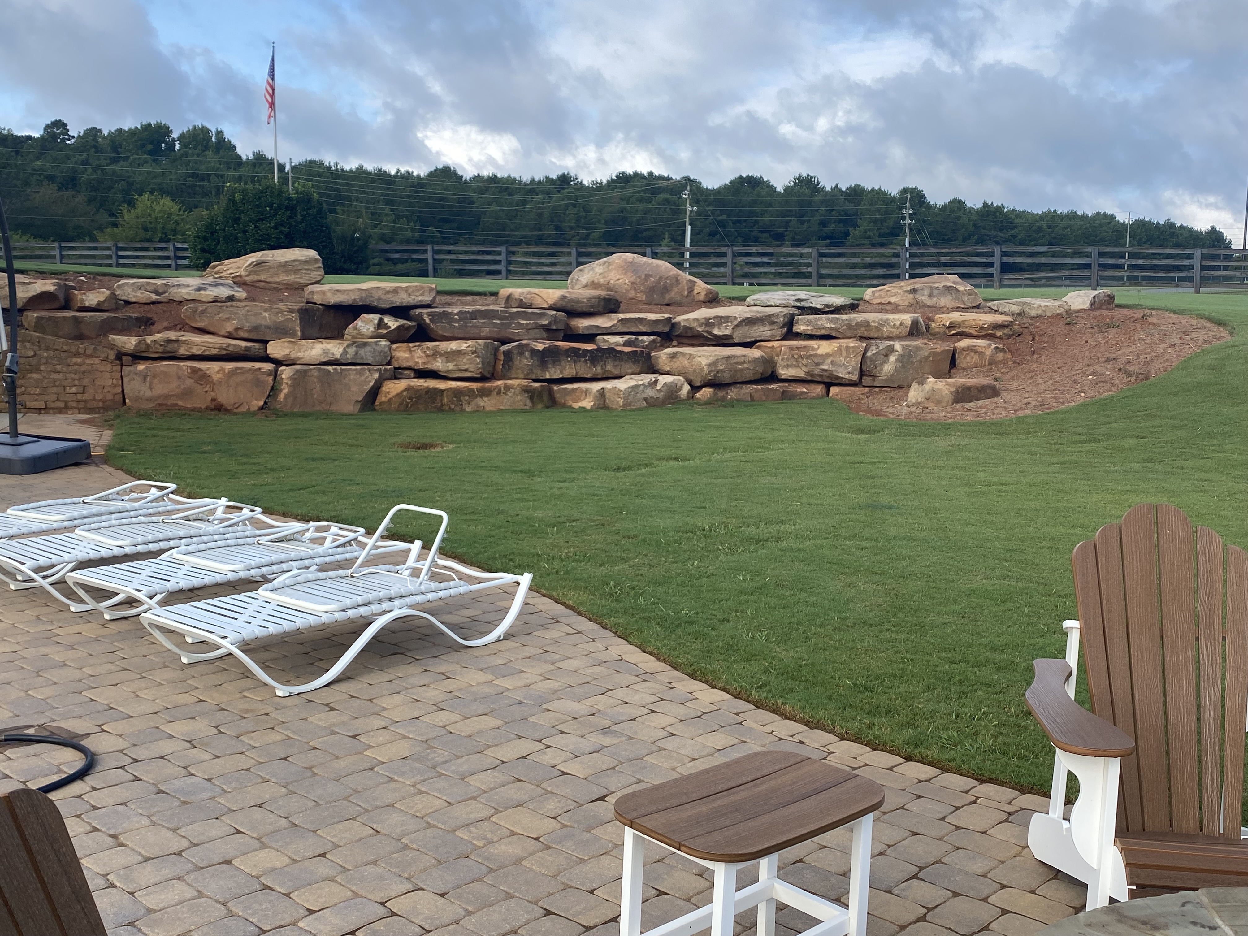 Boulder retaining wall with paver patio and lounge area in Cherokee County, GA