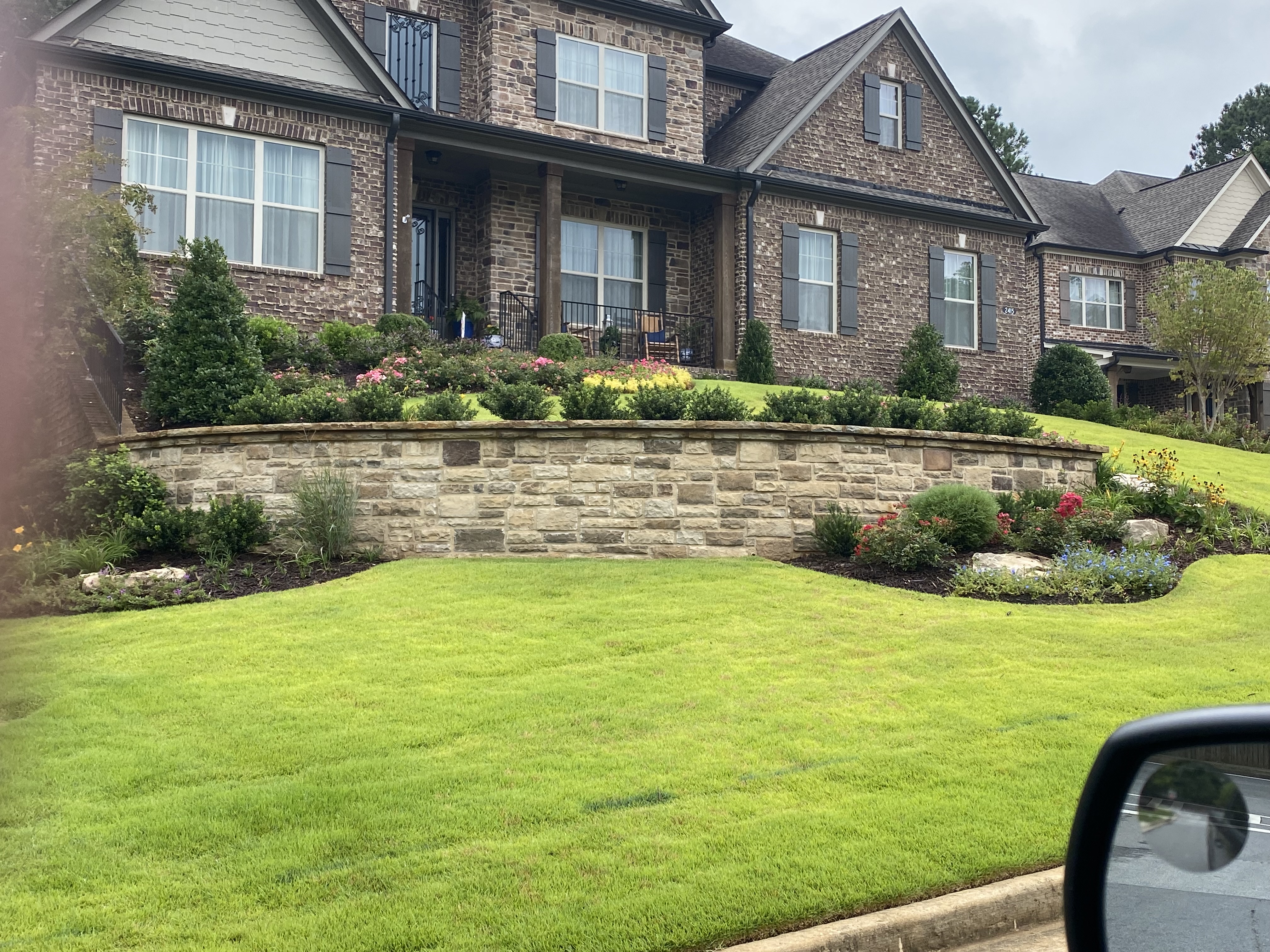Curved stone retaining wall with landscaping in North Atlanta, GA