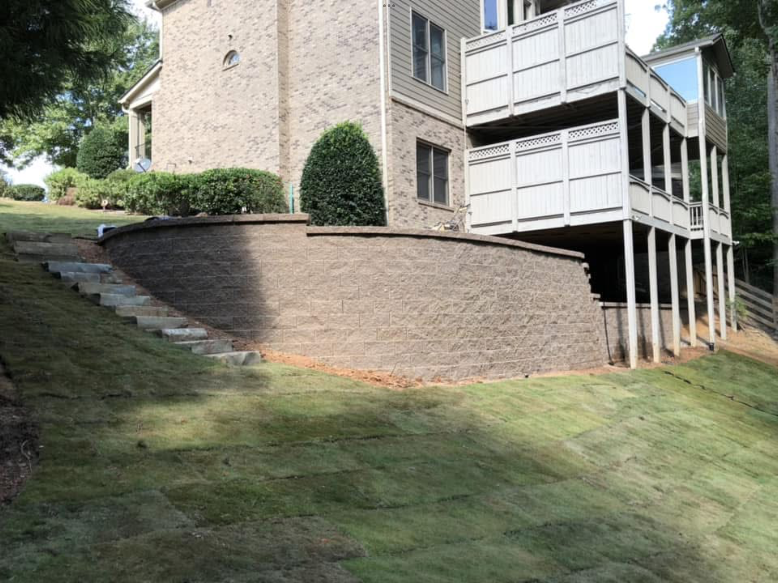 Curved block retaining wall with stone steps in North Atlanta, GA