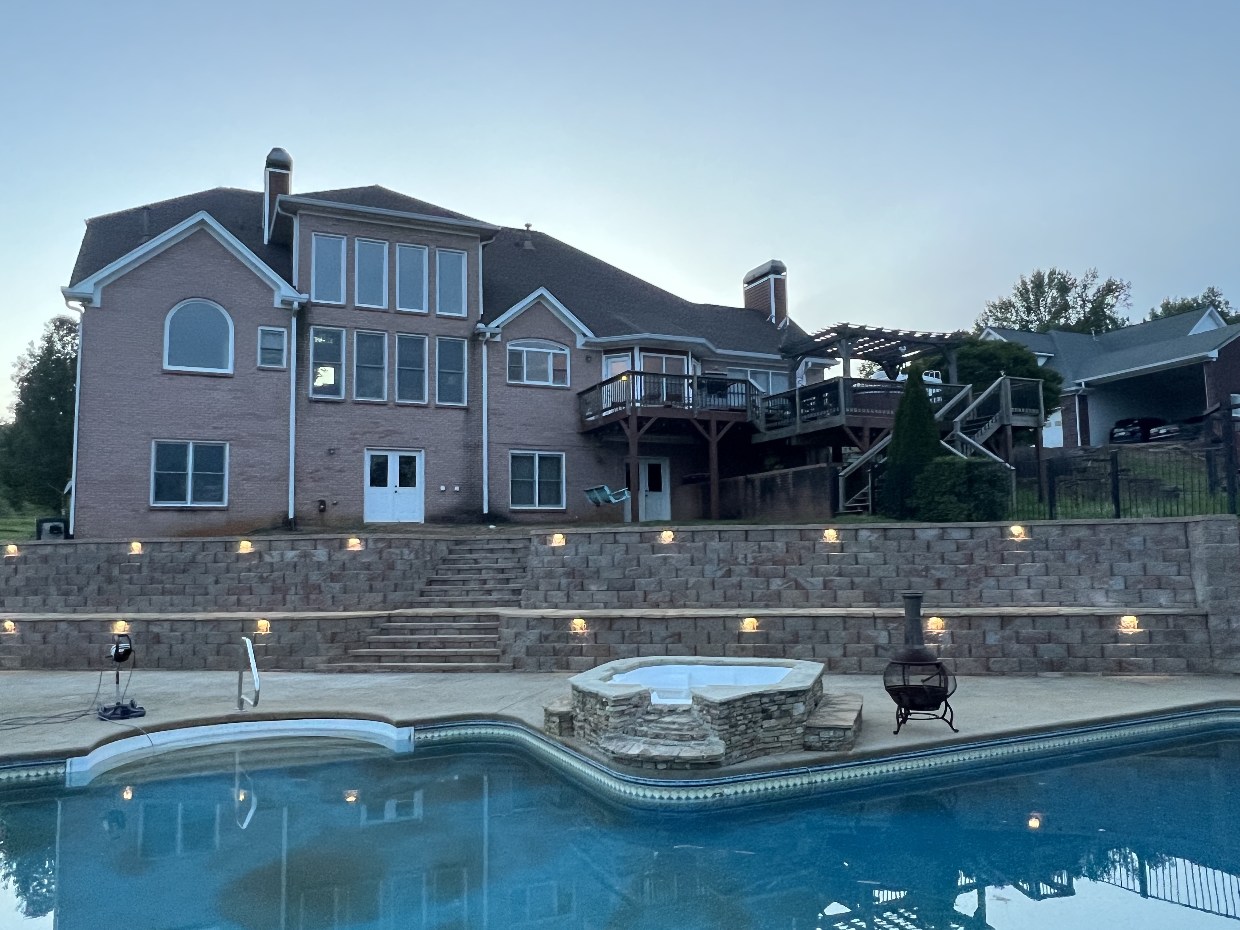 Lit retaining wall with pool and paver patio in North Atlanta, GA
